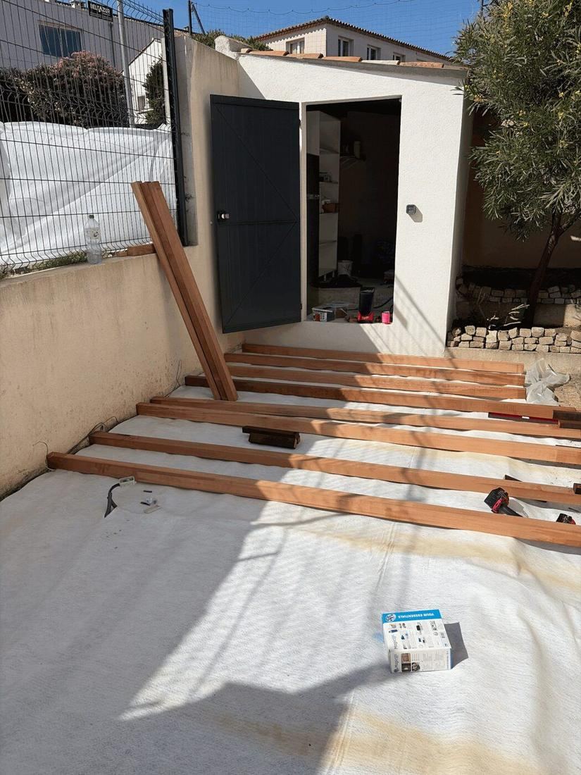 Structure d'une terrasse bois en cours de montage dans un jardin