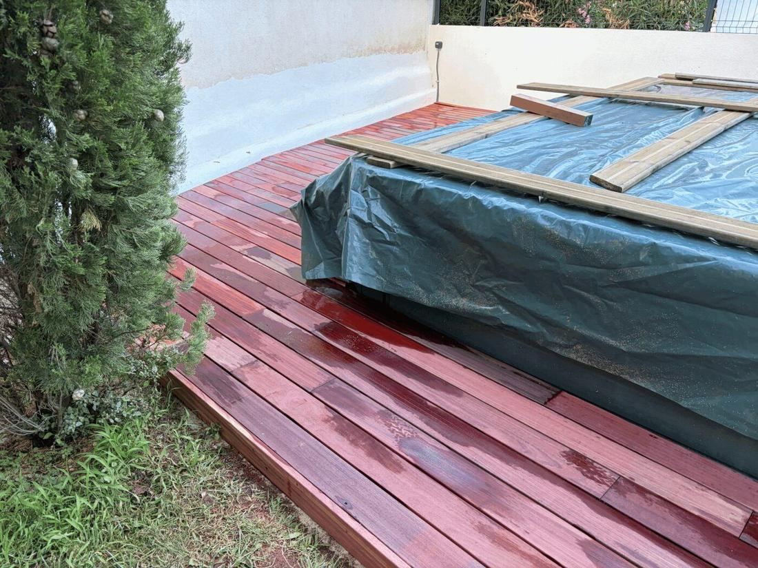 Terrasse bois aménagée autour d'un bassin dans un jardin