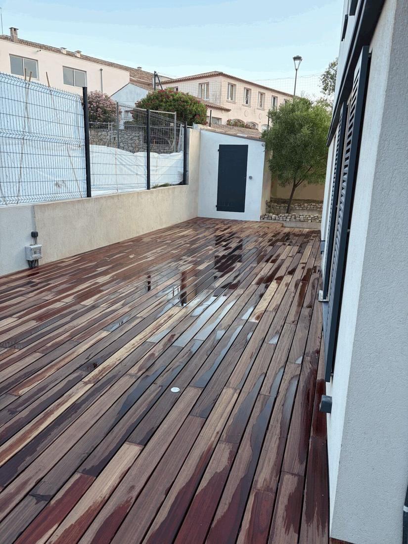 Terrasse bois livrée le long de la façade d'une maison